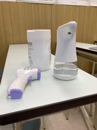 非接触温度計で体温のチェック、アルコール手指消毒液で消毒をしています。