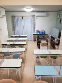 教室内の様子です。感染対策として、テーブルをパーテーションで区切っています。