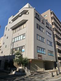 公園に面したグレーの建物の２階でエレベーターもあります。