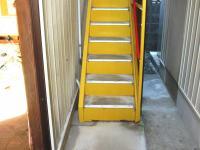 駐輪場奥の黄色い階段をお上がりください。