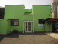 二本木小学校の西200mのところにあります。緑色の建物です。