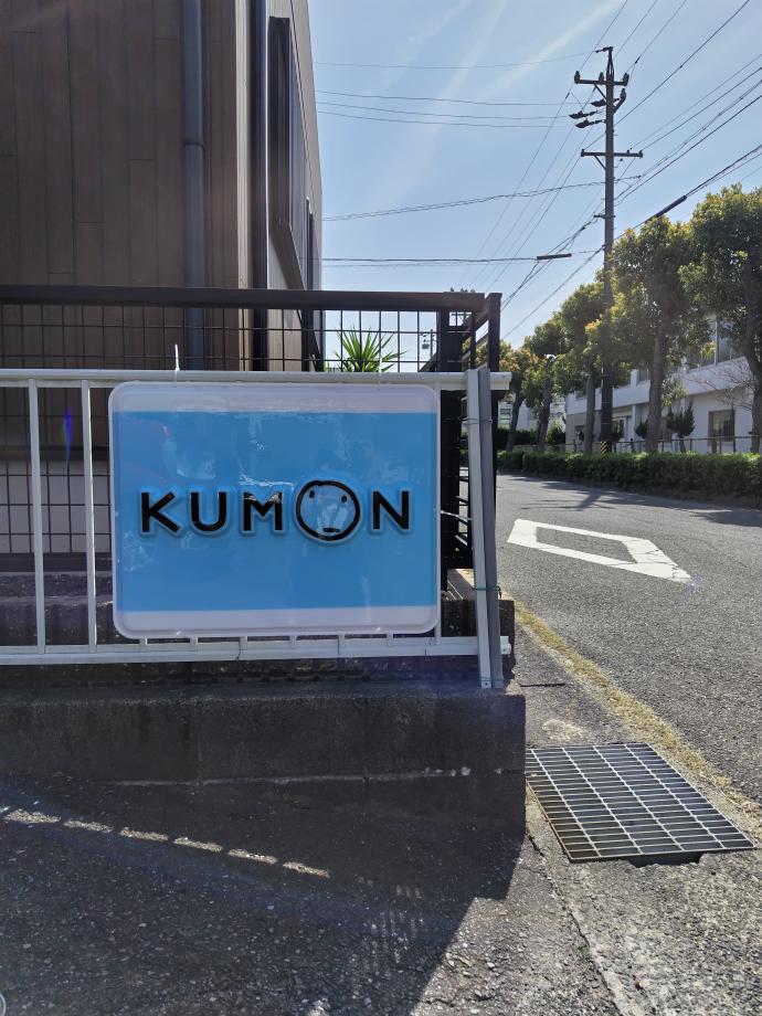 中央小学校正門から見えるブルーの看板。「くもんいくもん！」のKUMONです！