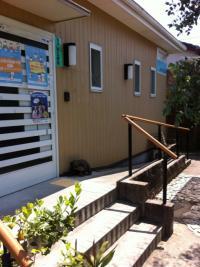赤茶系の屋根の平屋の建物、このような玄関が通りから見えます。