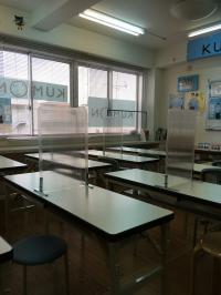 大きな窓がある明るい教室です<br />
机の上には、飛沫防止パネルを設置しています