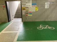 駐車場左手が駐輪場です。緑の枠内に自転車をとめ、横の階段を上がります。