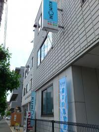 青い旗と看板が目印。階段をのぼって右手が教室です。