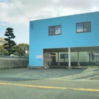 ブルーの建物です。左下付近の階段から2階へお上がりください。